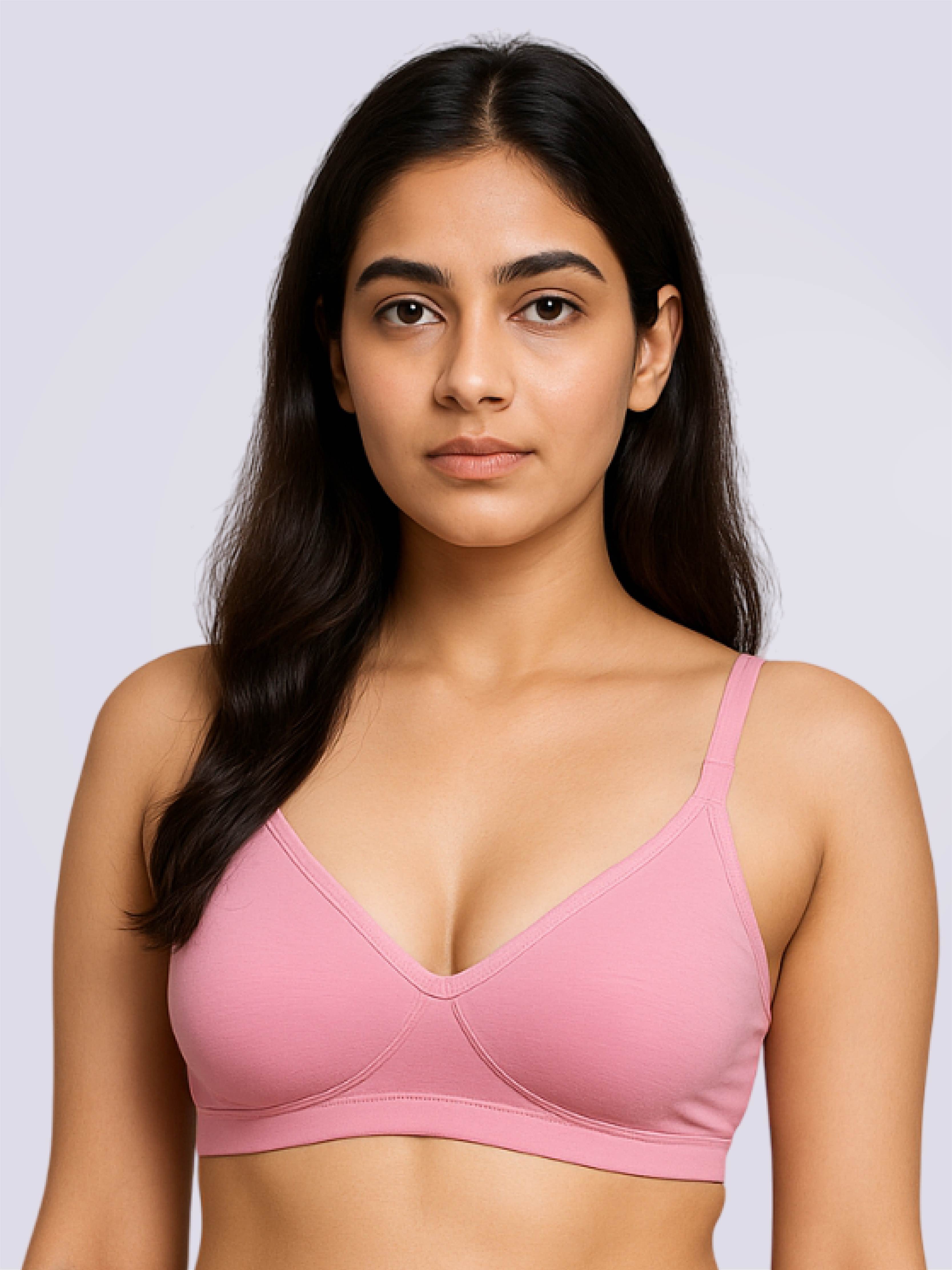 Woman wearing a pink bra against a light gray background